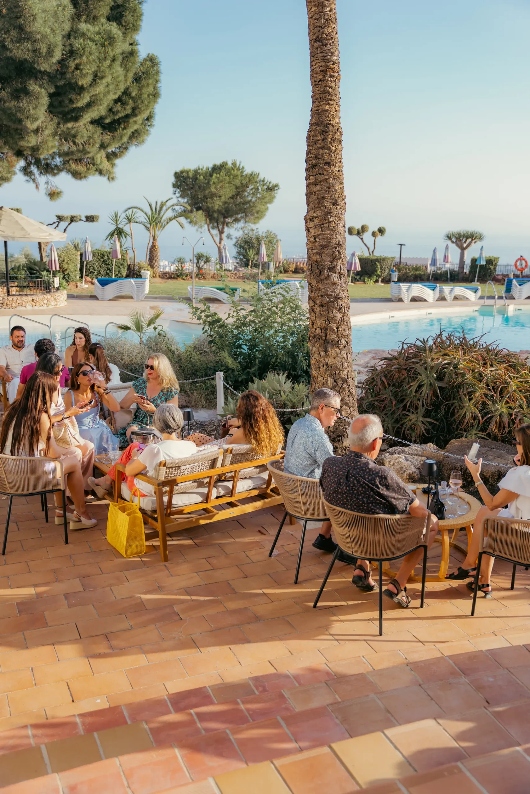 Terraza llena al atardecer en Tardeo by Origen, Nerja, con la piscina y el mar de fondo